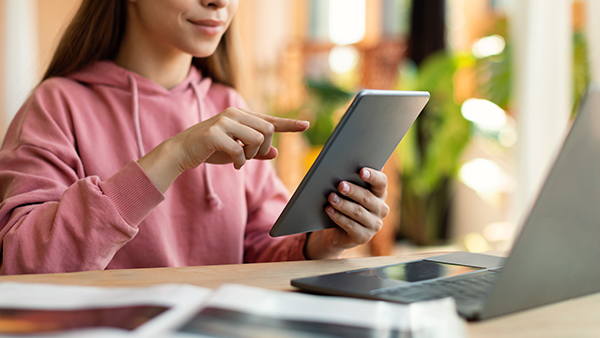 Female teenager using tablet and laptop